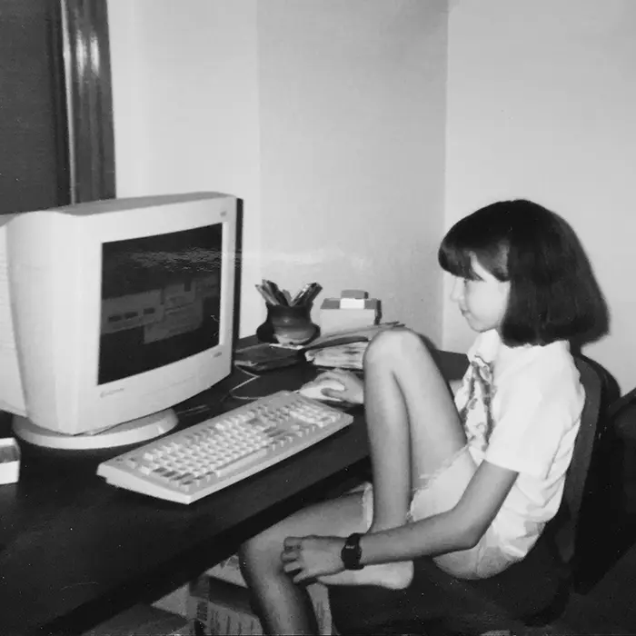 Polaroid style photo of young Jacquelyn at a computer